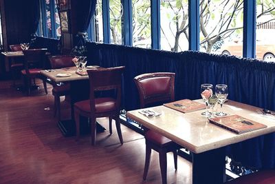 A photo of two-person tables by a window in a vintage tea house